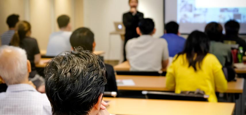 A group of people in a seminar, seen from behind